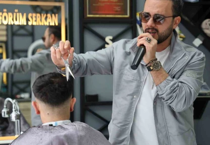 Bir elinde makas diğer elinde mikrofon